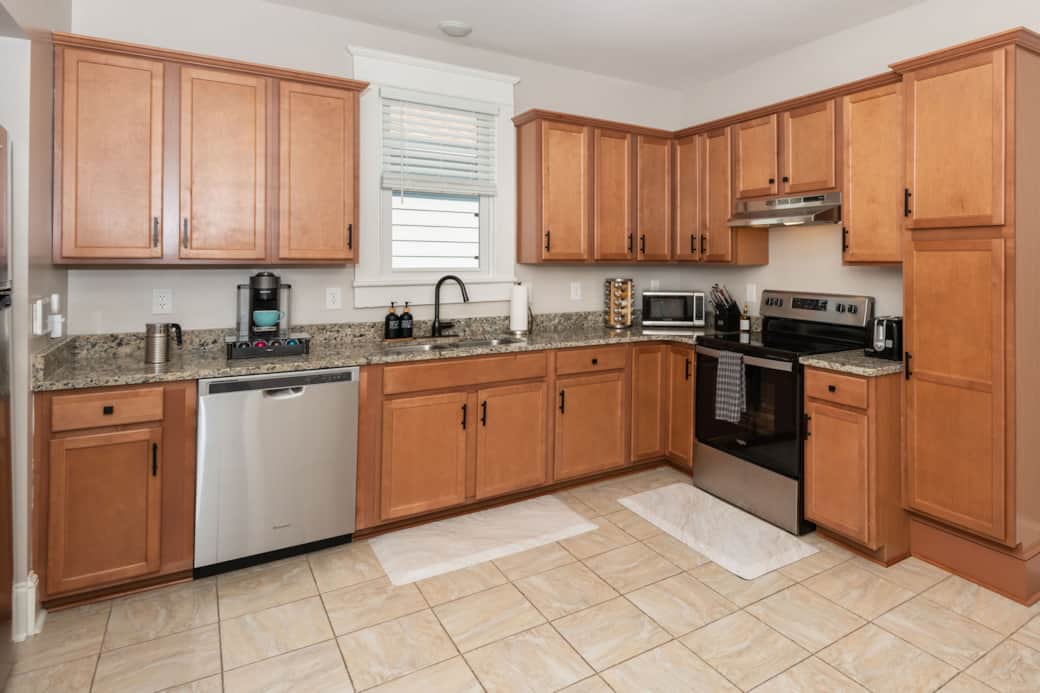 Full Size Kitchen with fridge, dishwasher, stove, oven, microwave, and coffee machine.