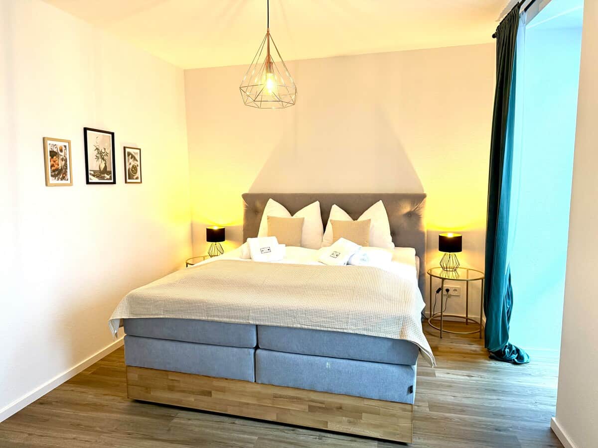 Beide Schlafzimmer sind mit bequemen, hochwertigen King-Size-Boxspringbetten ausgestattet und sorgen, gemeinsam mit feinster Hotelbettwäsche, für erholsamen Schlaf.
Im rechten, größeren Schlafzimmer steht dir zudem ein Schreibtisch zur Verfügung. 