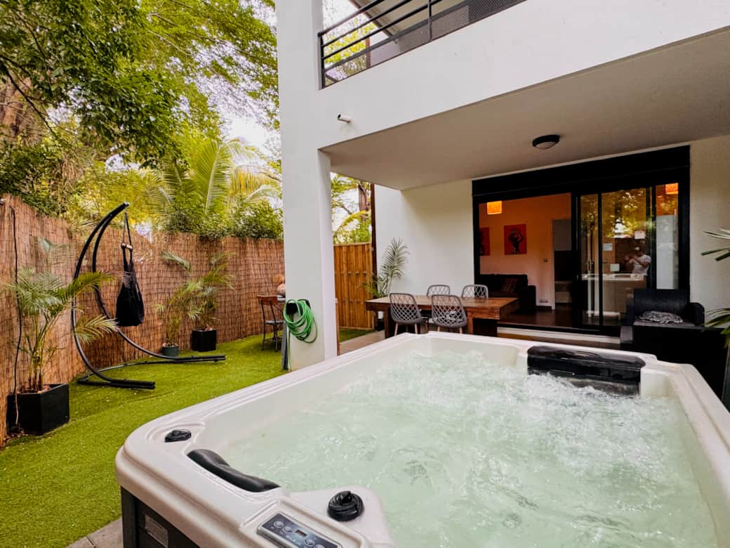 Espace extérieur avec jacuzzi, table à manger et salon de jardin pour des moments de détente