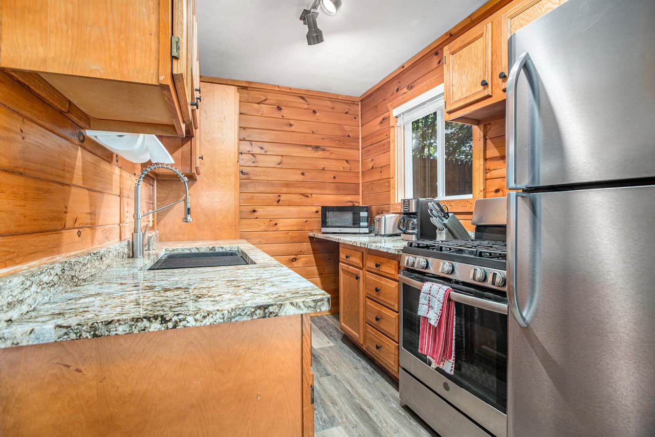 Fully equipped kitchen with gas range, full-size fridge and granite counters