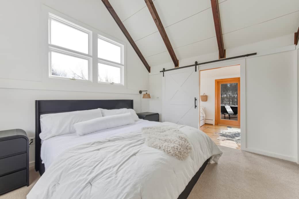 Serene primary bedroom with plush bedding and natural light