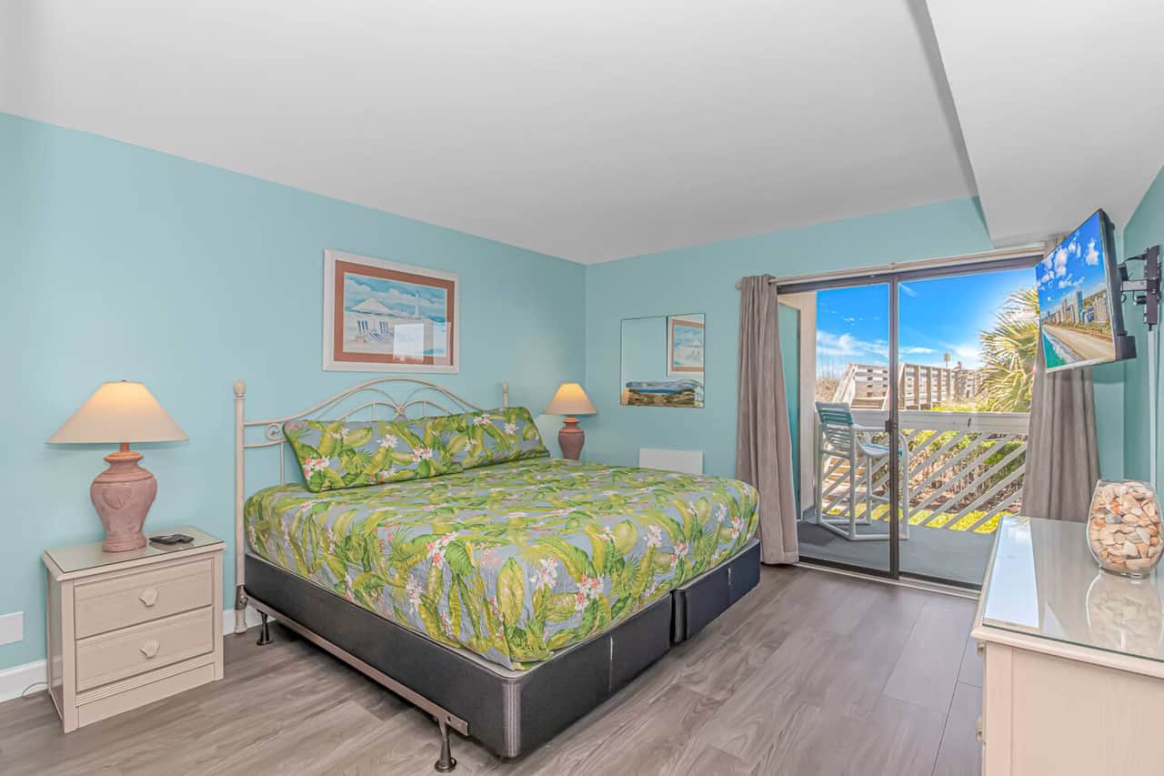 Spacious primary suite featuring a king bed and direct balcony access.