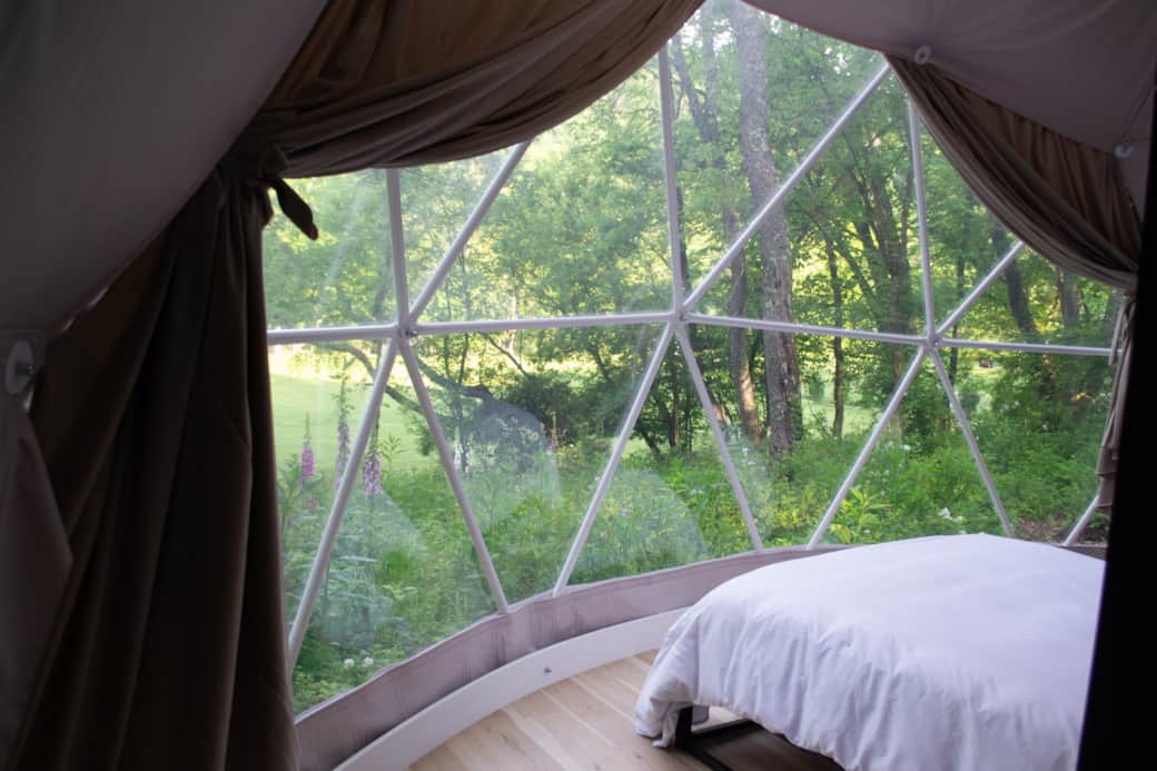Panoramic window in front of queen bed with scenic view into the forest