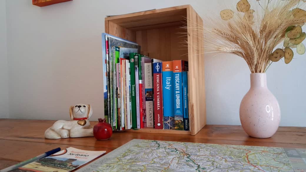 A small bookshelf with tourist guides, maps, and information for guests. A small bookshelf with tourist guides, maps, and information for guests.