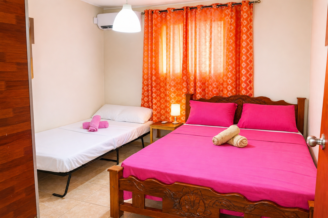 Air-conditioned bedroom with a double bed & a twin bed, wardrobe, mirror, and towels. 