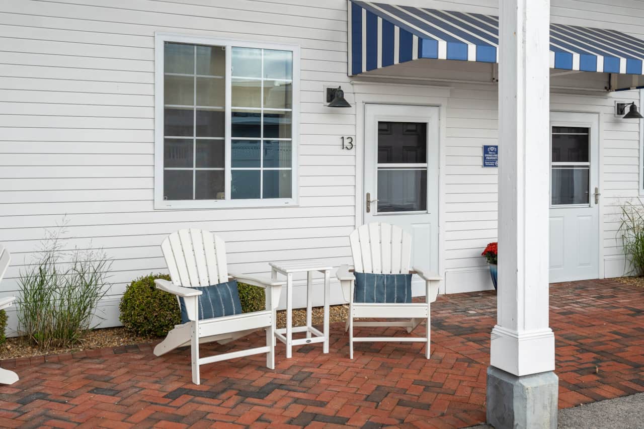 Patio area with two adirondacks and parking