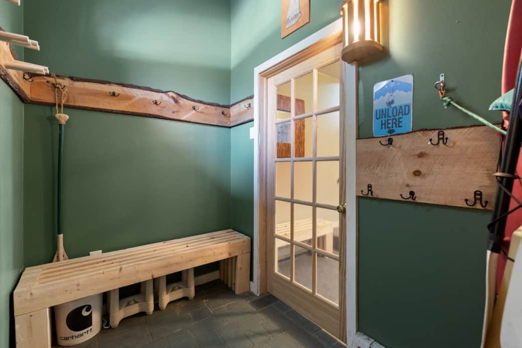 1st Mudroom from main entrance.  2 Boot/Glove warmers stored under the bench. 2nd mudroom visible through door.  A 3rd mudroom area is off the back deck.  Plenty of room, ski racks, and coat hooks to unload and store gear out of the way.