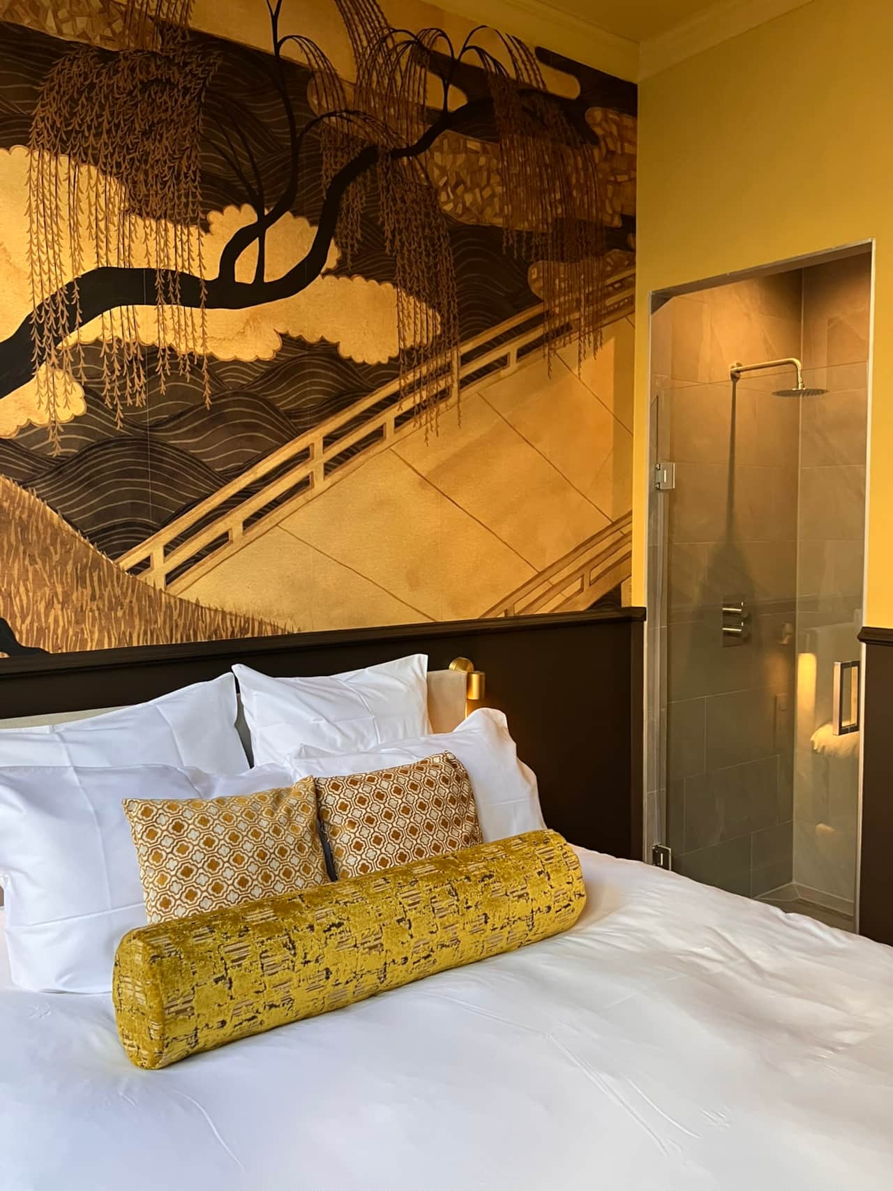 Aleida Suite bedroom with a glass-walled open shower visible behind the bed