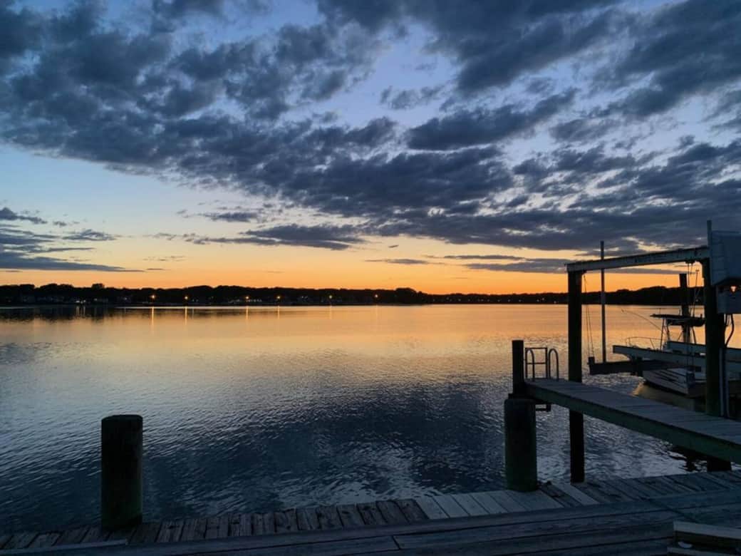 Private boat dock area with umbrellas, fire pit, and beach sand