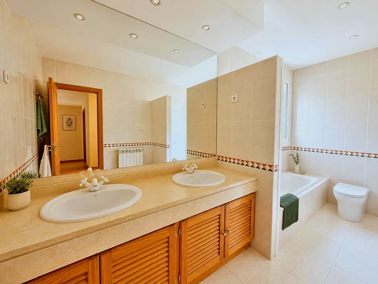 Baño principal con bañera y dos lavabos