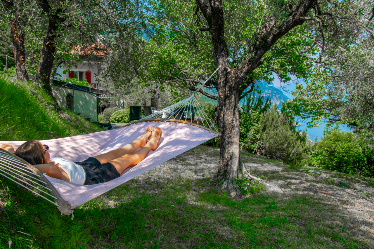 Hammock in the private garden overlooking the lake, among olive trees, natural shade and relaxation above Garda in the villa