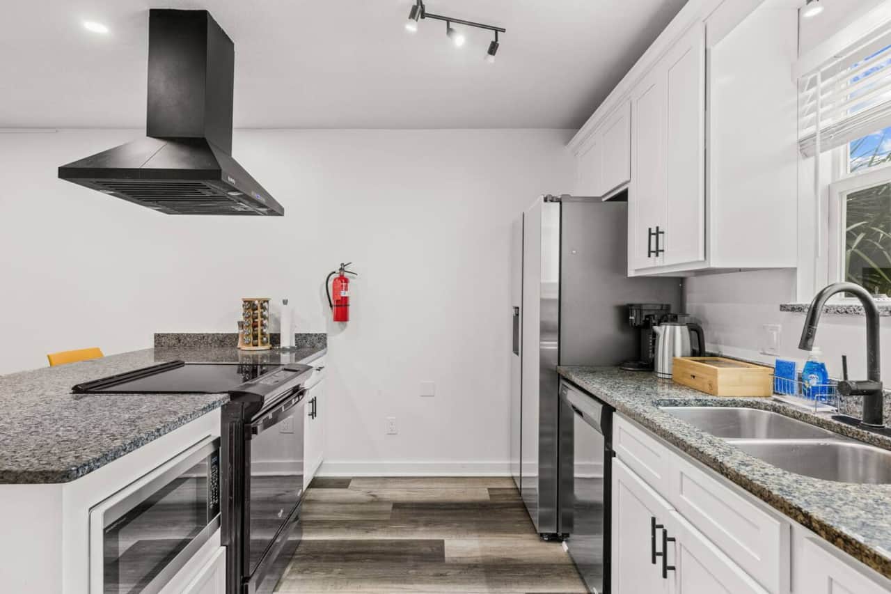 Prepare meals with a new Samsung refrigerator, new Sharp microwave, dishwasher, and full stove and oven. The spacious kitchen includes a large island, cookware, bakeware, dinnerware, and utensils for breakfasts, baking, and family dinners