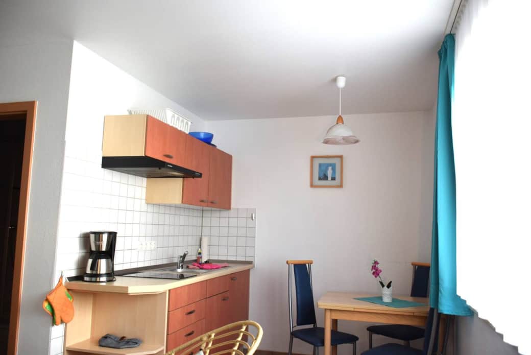 In der Küchenzeile gibt es neben der Essecke mit  ausklappbaren Esstisch & Stühlen, einen Herd mit 2 Kochfeldern, Kühlschrank ohne Gefrierfach, Koch- und Essgeschirr, Besteck, Wasserkocher, Toaster und Kaffeemaschine. 