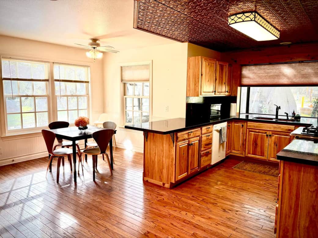 Bright and open kitchen with breakfast nook with abundant natural light from large windows. 
