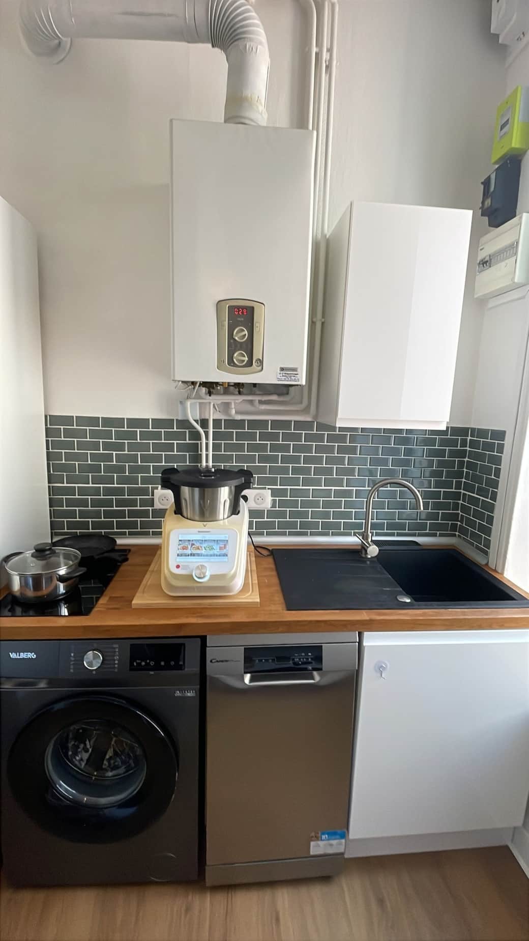 Cuisine avec plan de travail en bois, plaques à induction, MONSIEUR CUISINE CONNECT, Lave vaisselle, évier encastré, lave-linge.