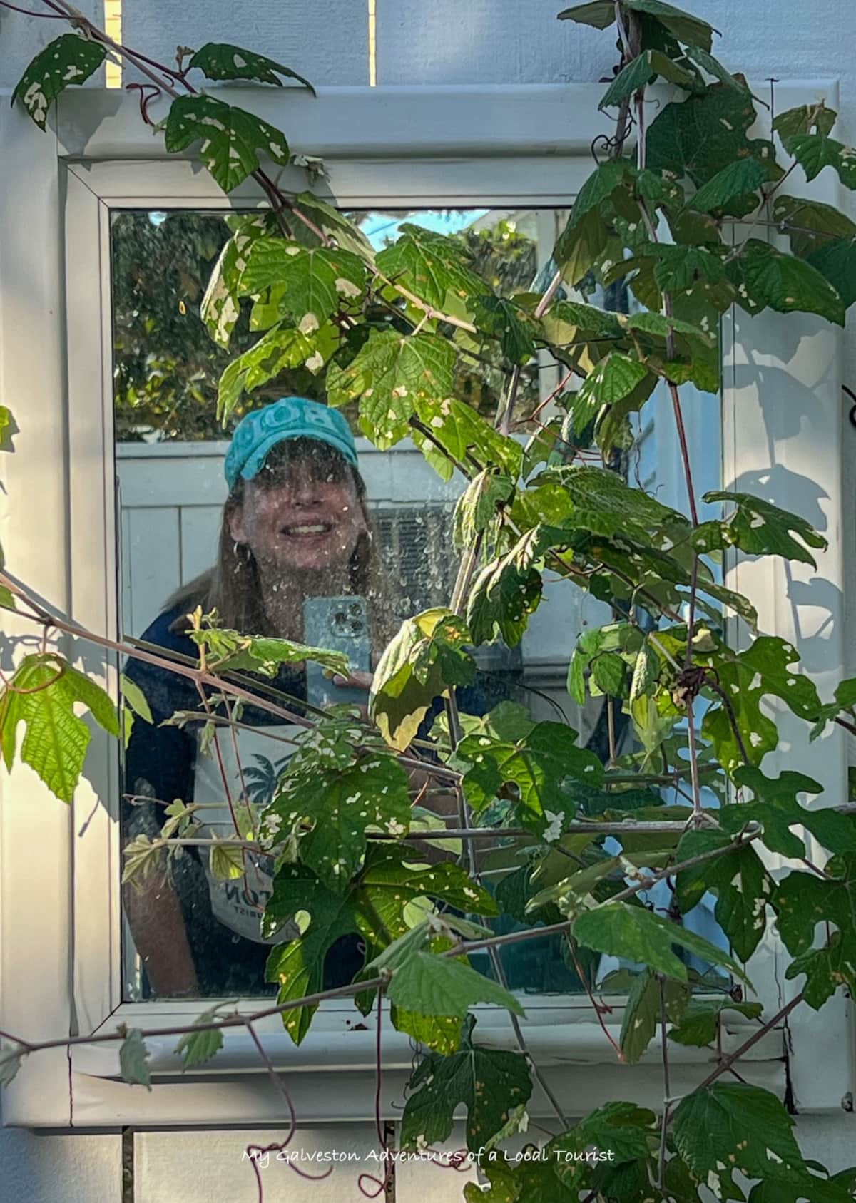 kelly-chapman-peeking-through-a-mirror-by-outdoor-shower-at-white-magnolia