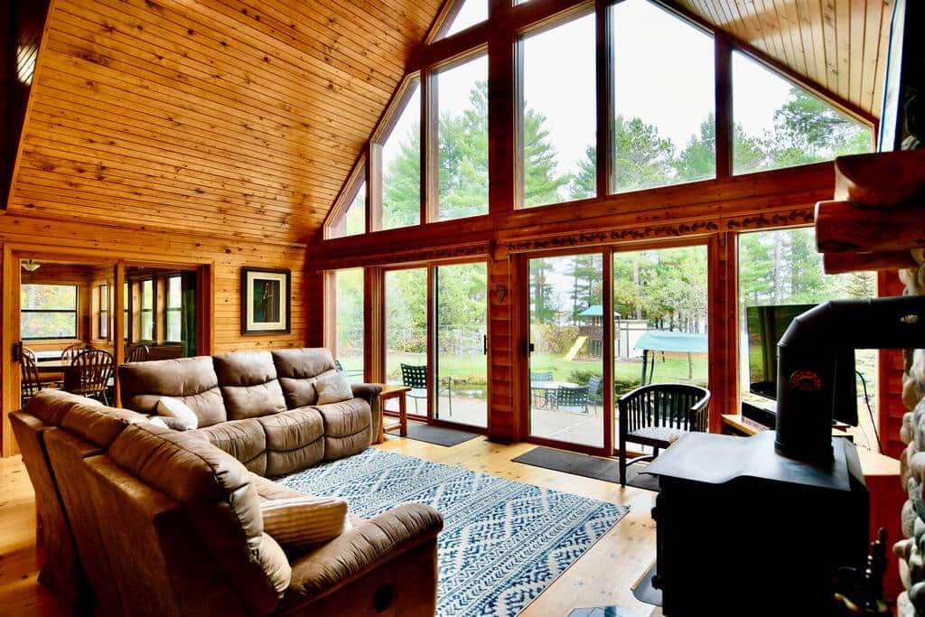 Gaze on the expansive yard, pond, gardens, pine trees, and lake from the living room.