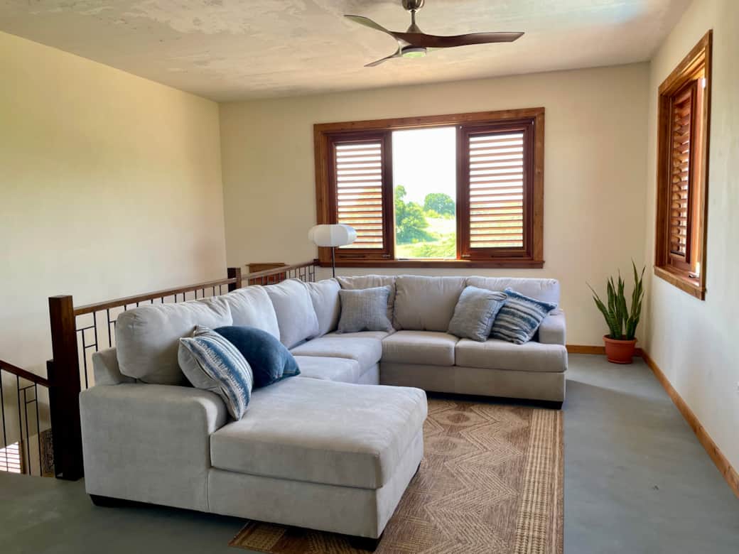 Upper level living area furnished with large sectional and smart TV.