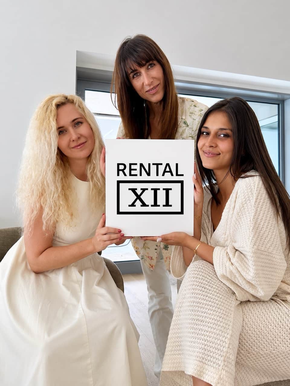 Anastasia Duke, Floriana and Kristina holding up the RENTAL12 logo at the Olbia head office