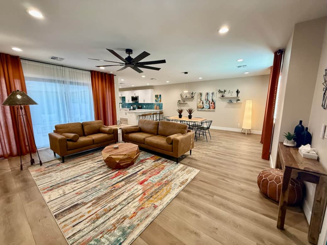 Immediate view when entering the home. View of living room, dining room and kitchen. Access to courtyard is through double glass sliding doors behind curtains.