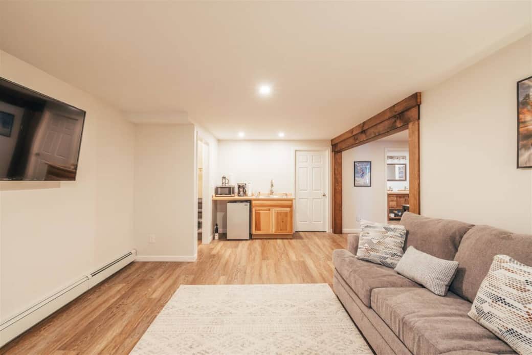 Large living area with couch, love seat, kitchenette and smart TV