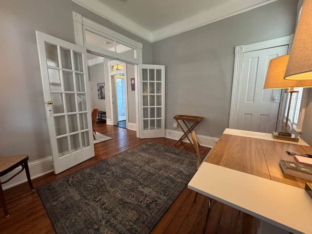 The office features an adjustable desk for sitting or standing while you work, and French doors that can be closed for added privacy.