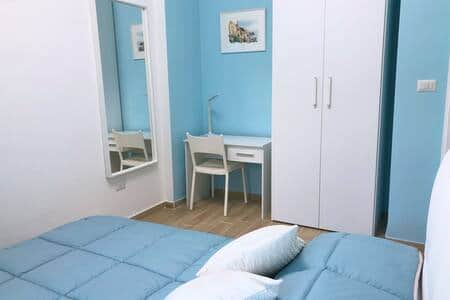camera da letto secondaria con dettaglio armadio a due ante, scrivania con lampada a LED e presa USB