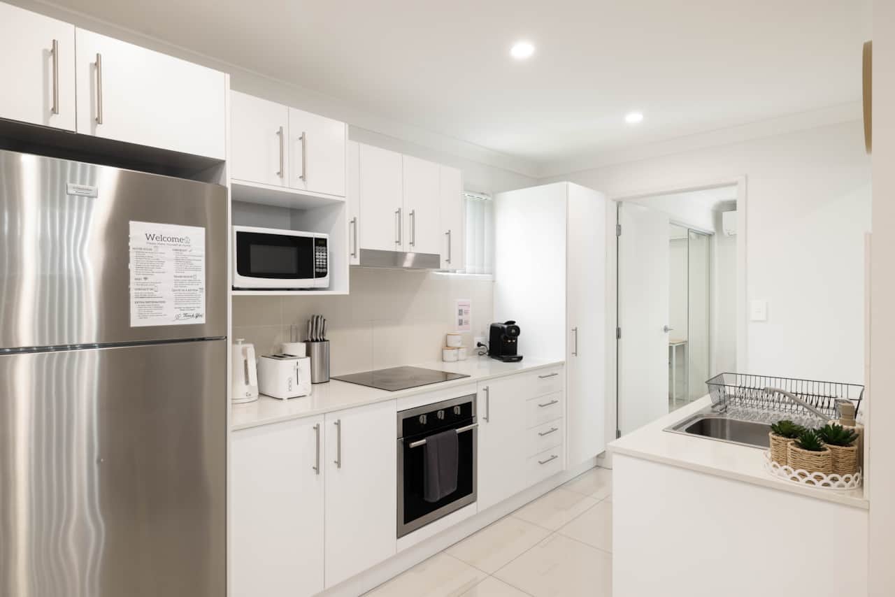 Kitchen: Sleek kitchen with ample storage, modern appliances 