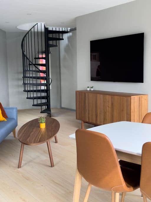 Admire the round staircase, an elegant feature that connects the two floors of the apartment