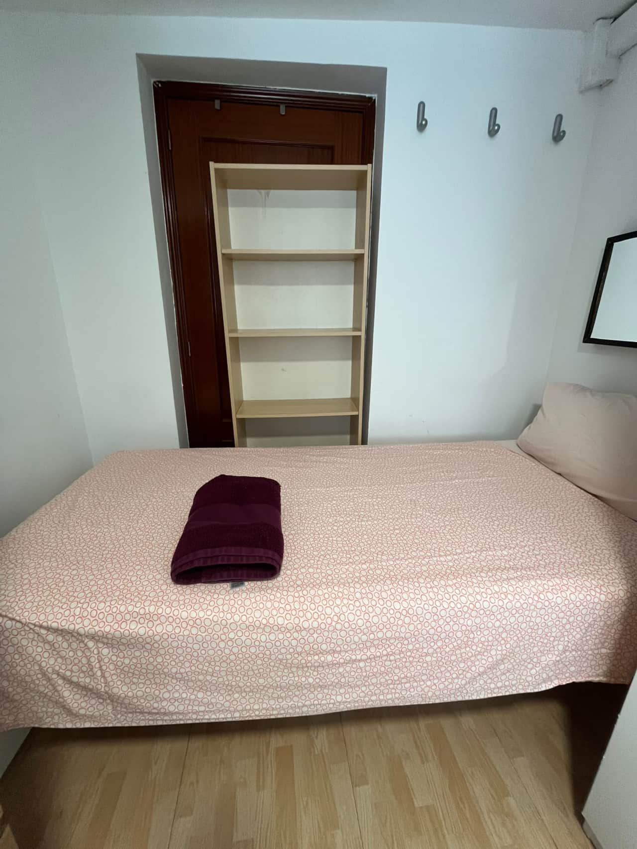 Single bedroom with bookcase and wall hooks