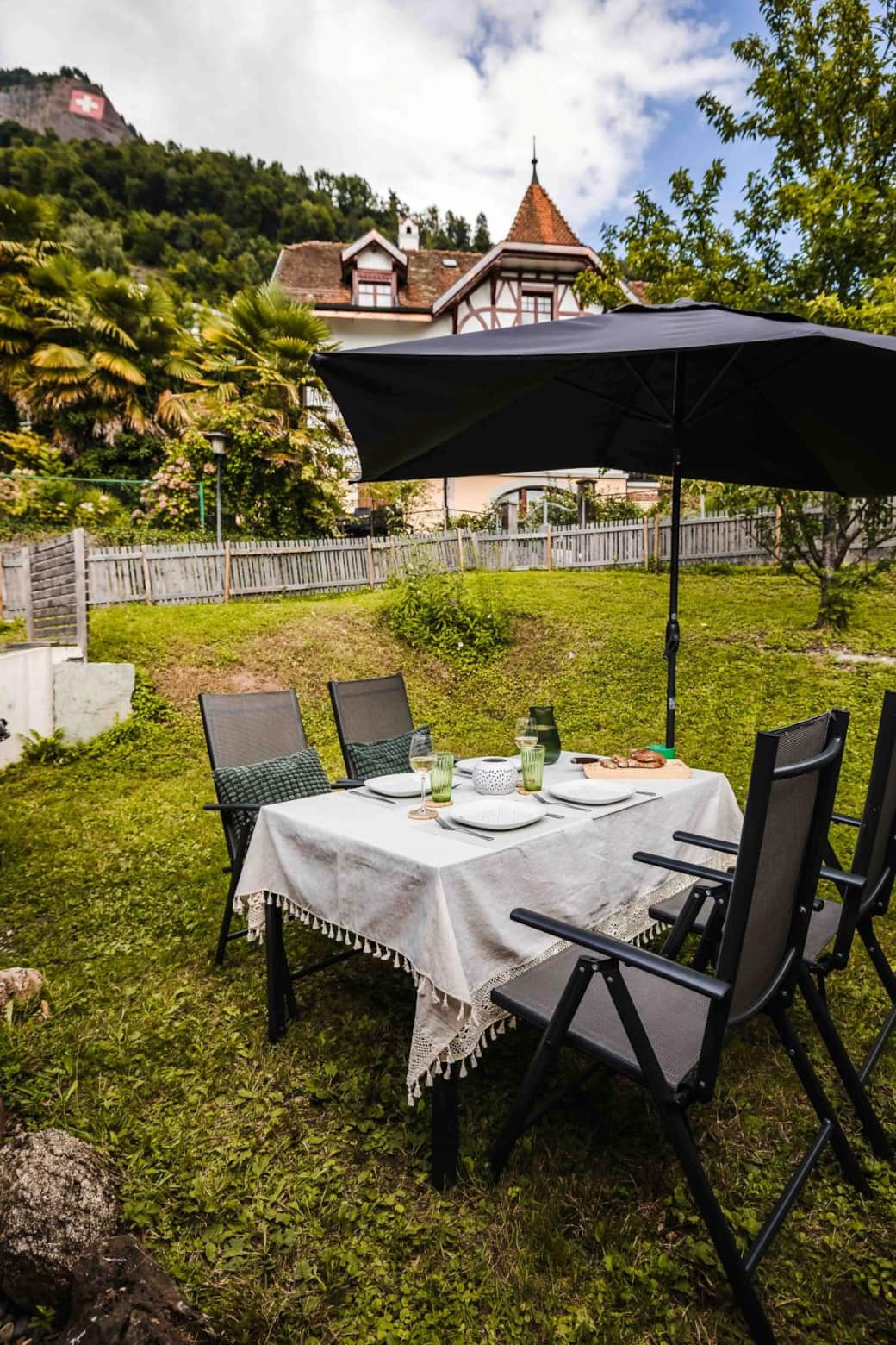 Garden dining area at Chalet Oz with mountain backdrop and umbrella Garden dining area at Chalet Oz with mountain backdrop and umbrella