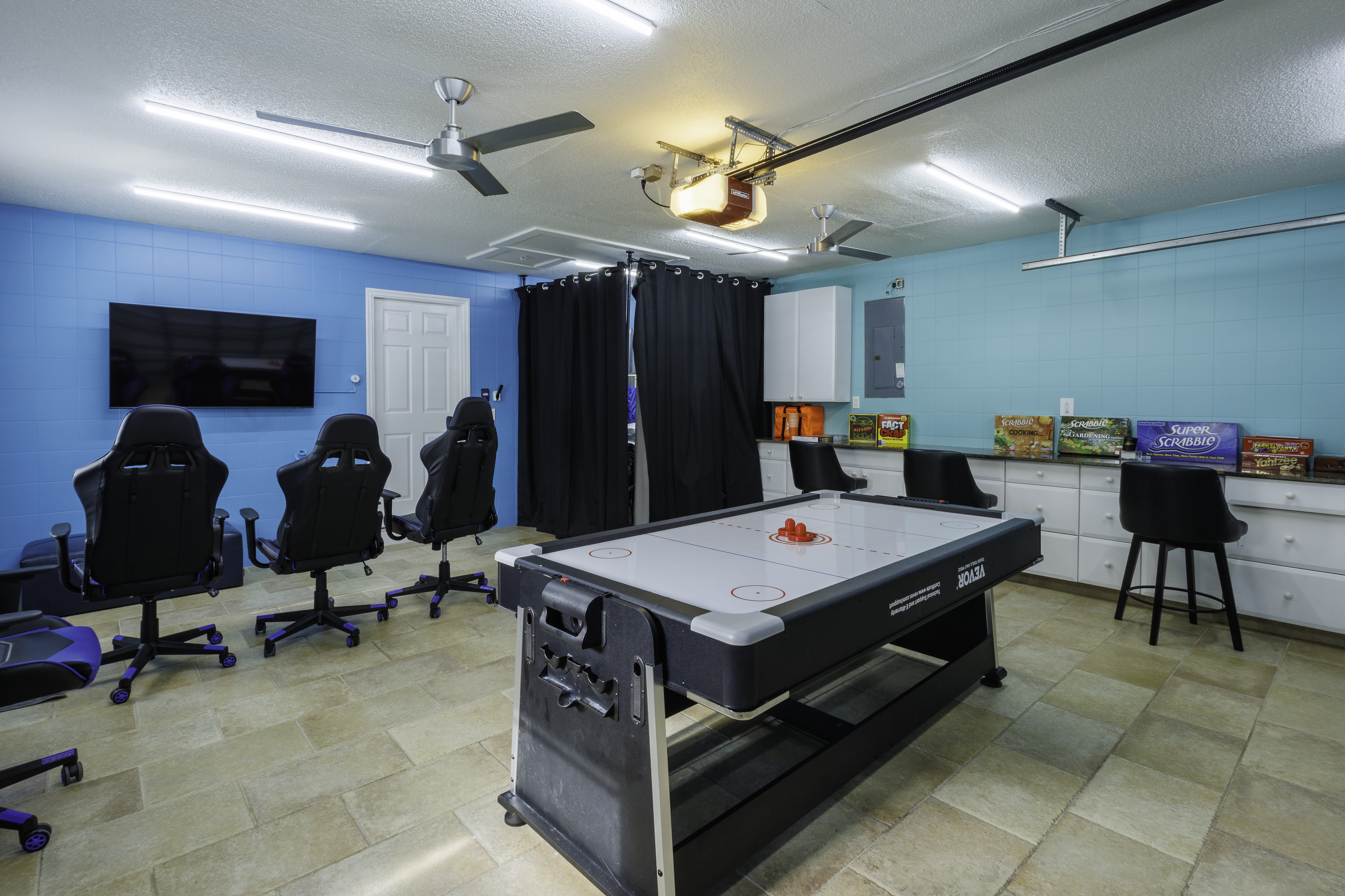Enjoy a fun game room with an air hockey table, TV, gaming-style chairs, and board games.