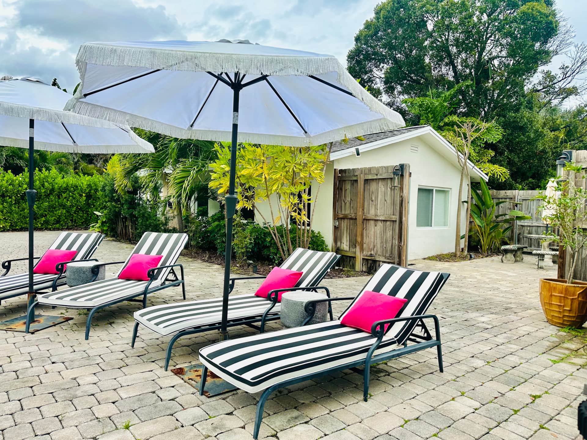 Renovated exterior at Casa Citron with European style tumbled pavers, lush landscaping, and private gate to the pool deck