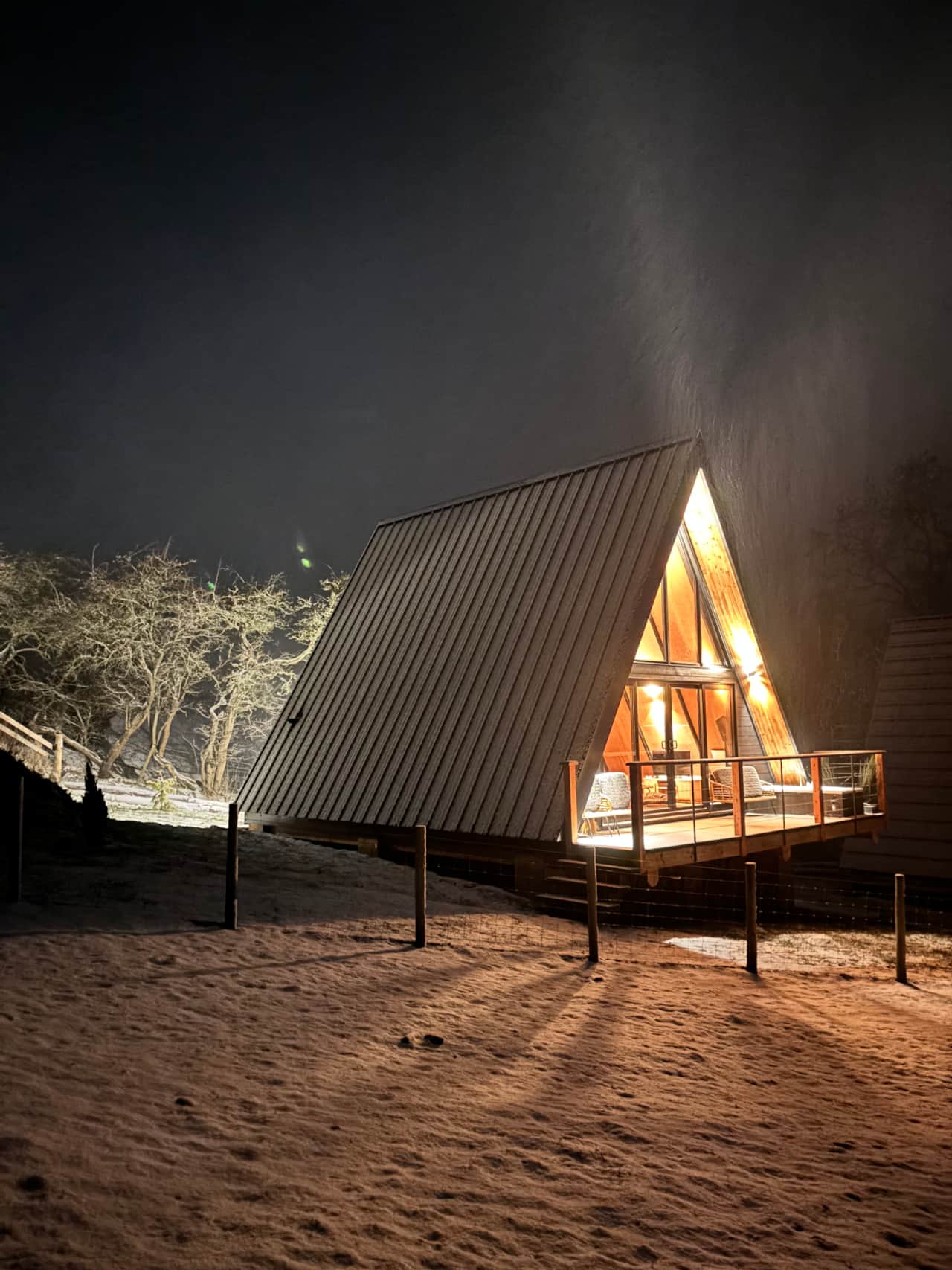 Frida Lodge illuminated by night in snowy scenery.