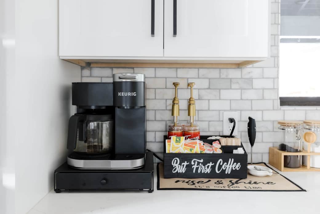 Fully stocked coffee bar has both K-cups and a coffee pot.