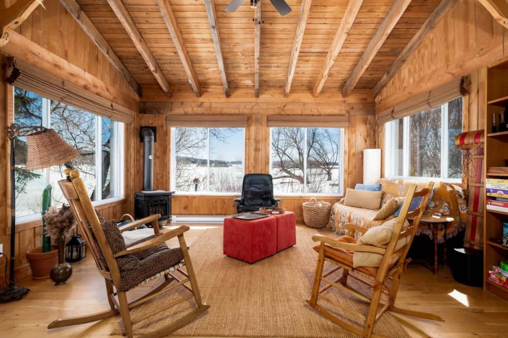 Véranda avec vue à 360° sur lac et jardin; zone de jeux pour petits et grands, coin bureau, foyer.