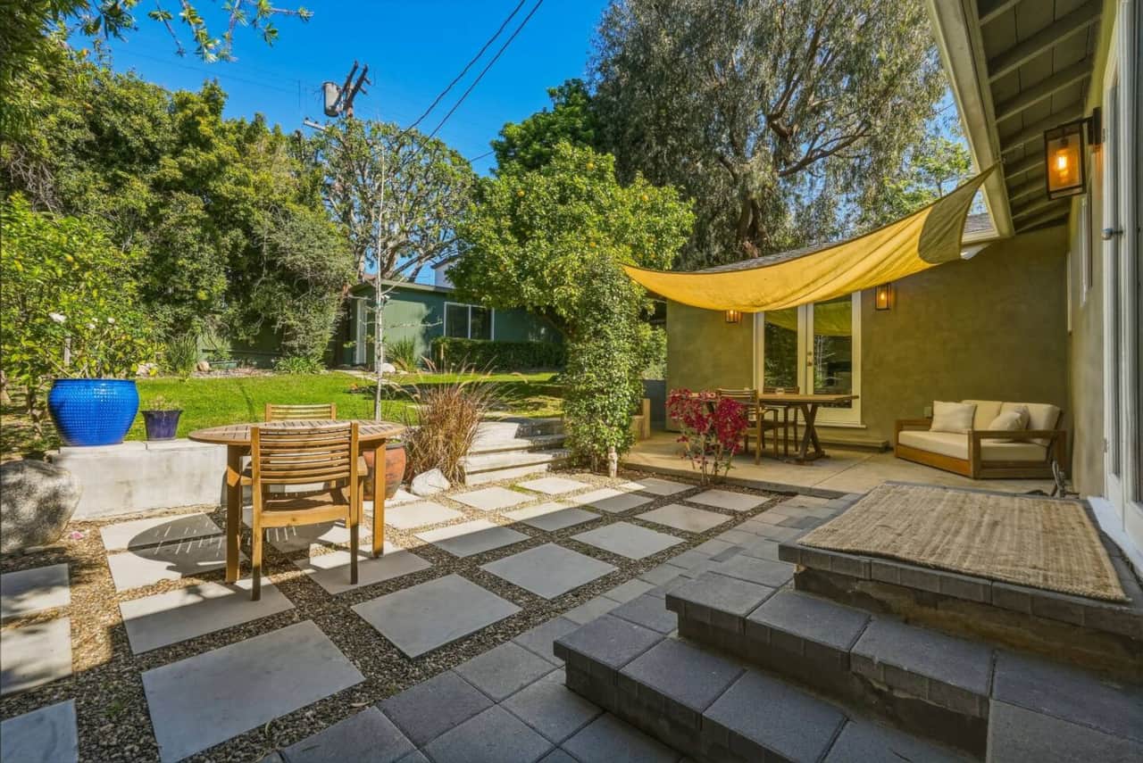 The patio provides extra seating with this two-seat outdoor sofa, creating a comfortable spot to relax and enjoy the backyard.