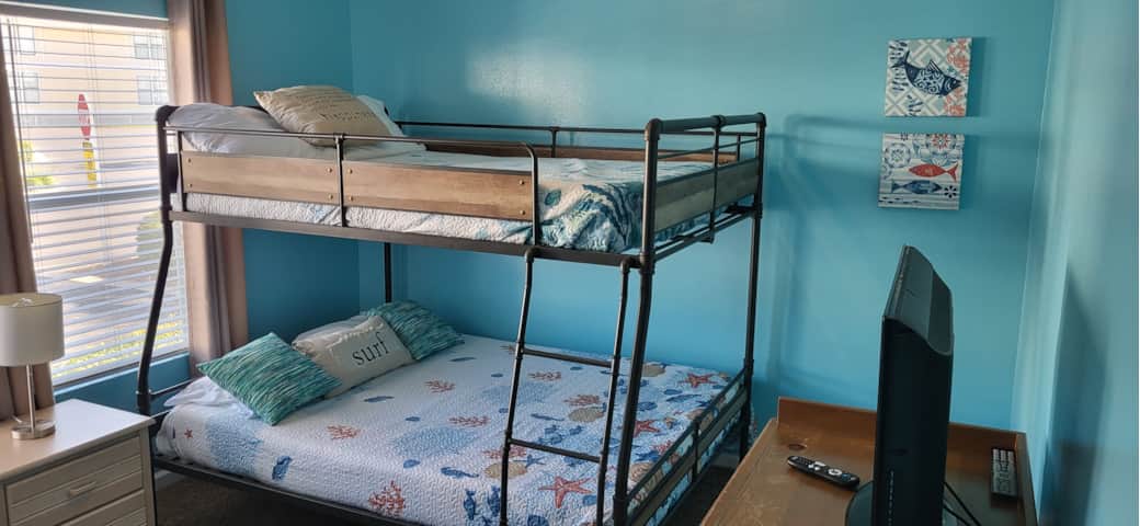 Comfortable second bedroom with full-over-queen bunk beds and TV. Comfortable second bedroom with full-over-queen bunk beds and TV.