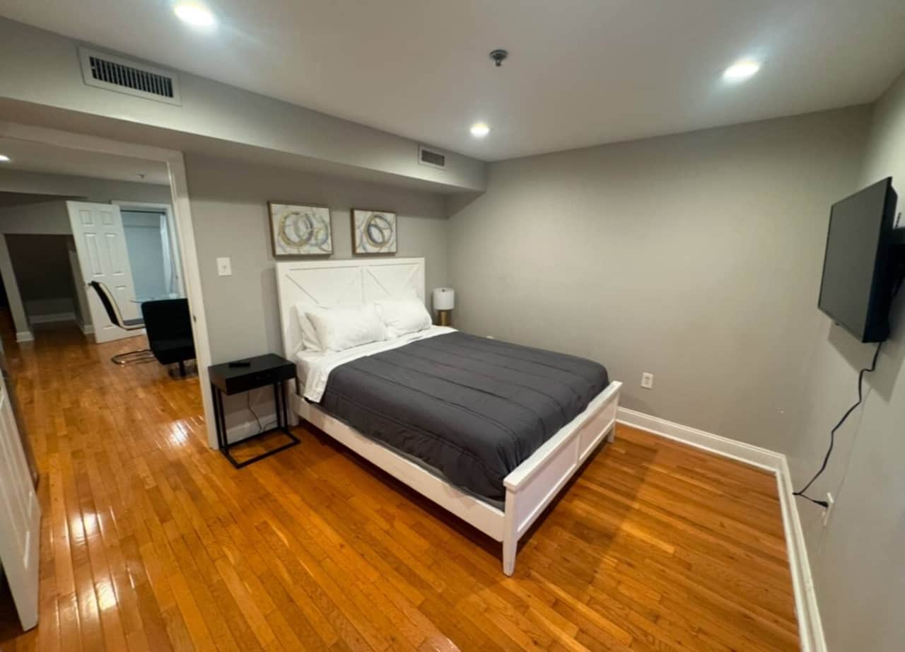 
Relax in our well-appointed bedroom, featuring a comfortable queen-sized bed and a convenient nightstand. Enjoy ample storage space with a large closet.
For entertainment, a flat-screen TV is provided, ensuring a pleasant and restful stay