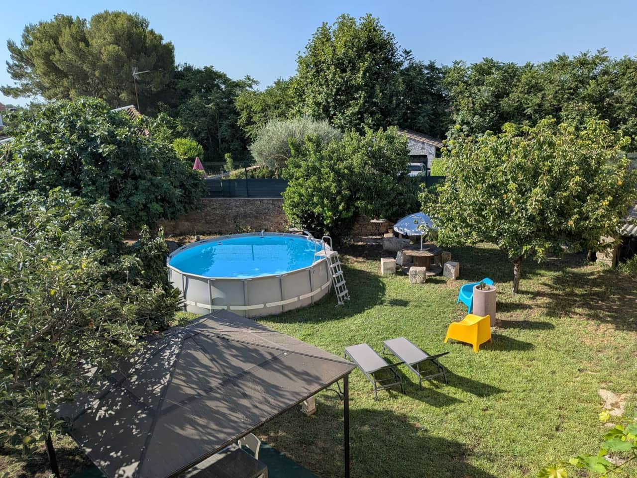 Large, enclosed garden with trees and a swimming pool
