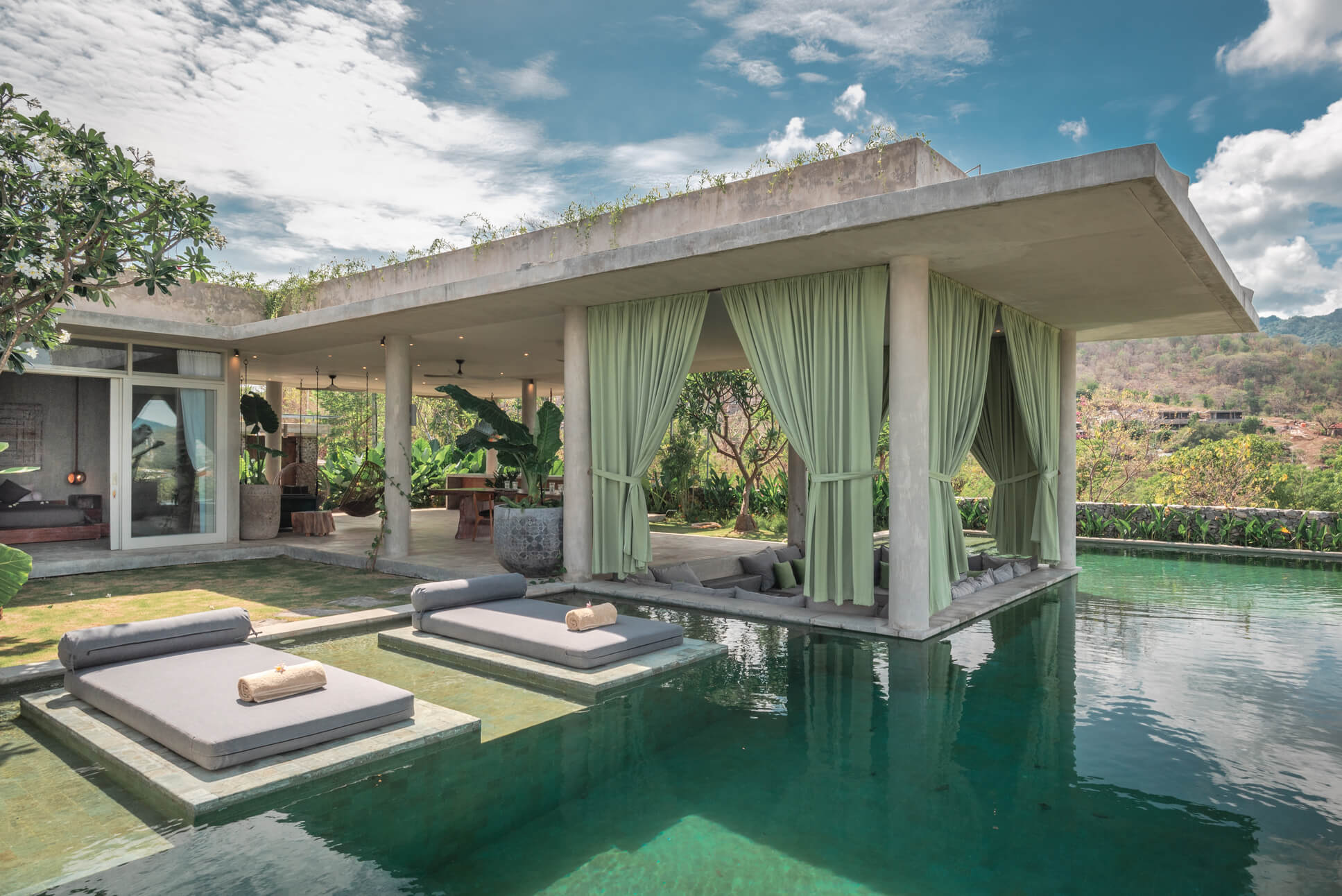 Private infinity pool and sunbeds at Villa Simcurik with shaded lounge and valley views