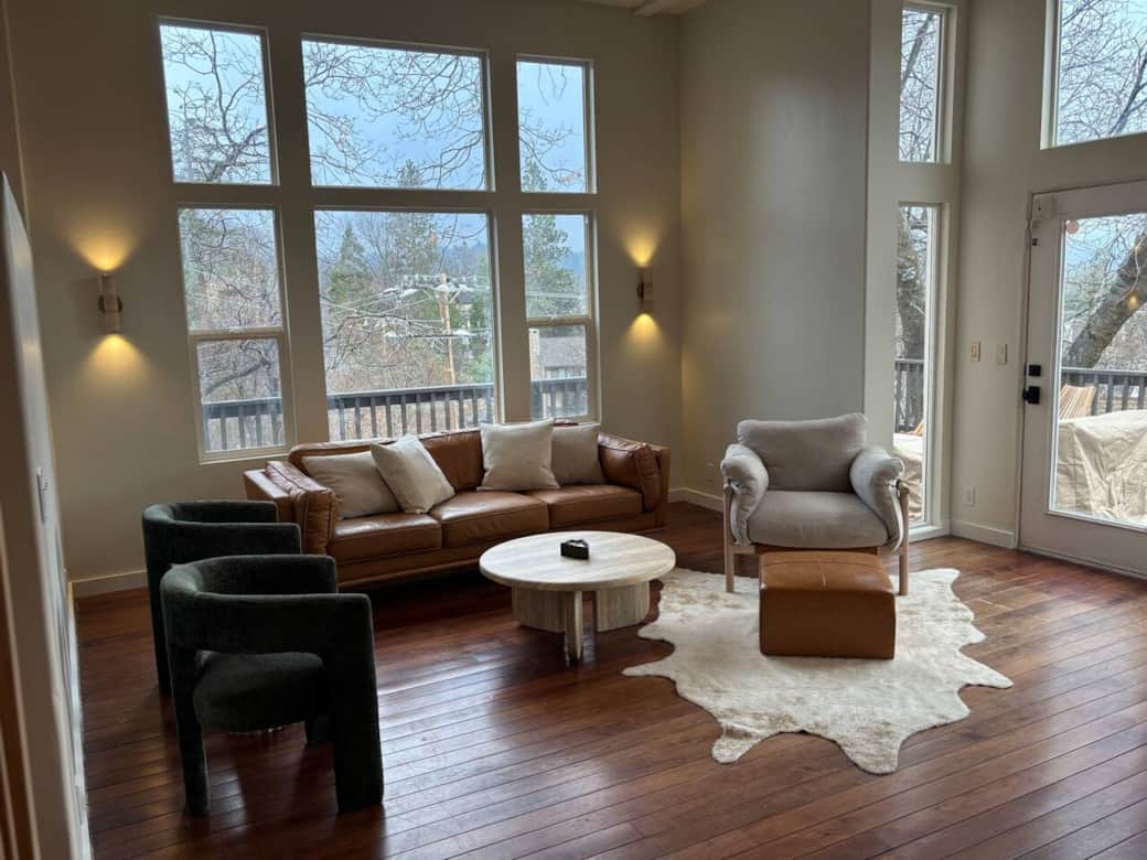 Cozy up in the Article leather sofa and Article upholstered chair by the fireplace with views of the lake from the windows