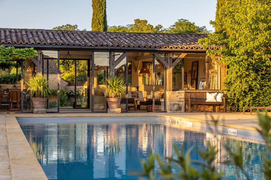 Le pool house et sa terrasse au bord de l’eau, écrin de pierre et de verdure pour des après-midis suspendus hors du temps. 