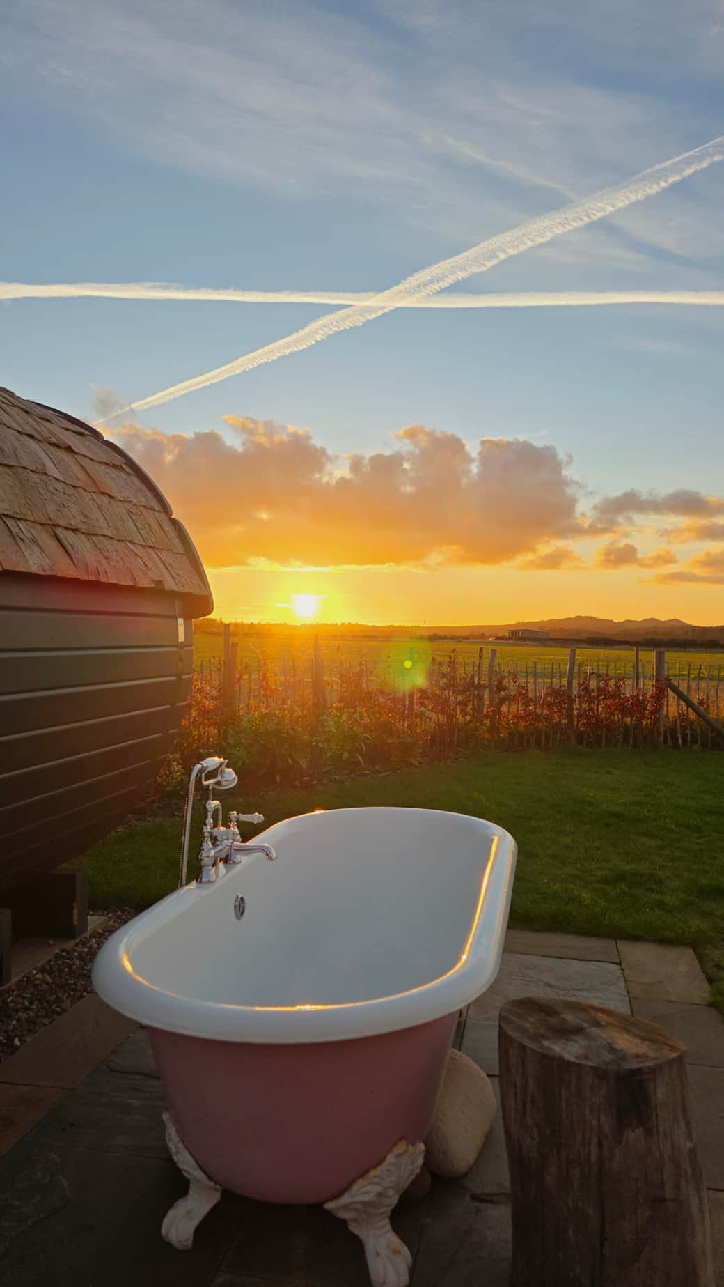 Our iconic pink roll top bath as the sun sets
