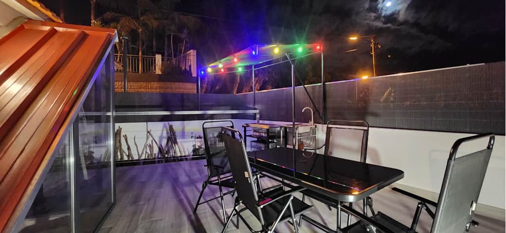 Floeca rooftop at night—open-air dining, colorful lights, ocean-side Madeira escape Floeca rooftop at night—open-air dining, colorful lights, ocean-side Madeira escape