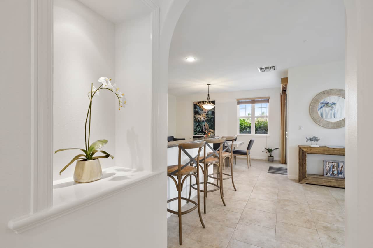 Dining area with orchid centerpiece, open to kitchen