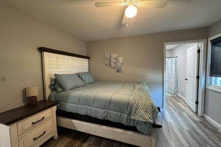 he bed is dressed in soft, light-colored linens, and the space is complemented by a TV