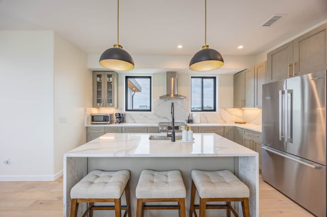 Modern kitchen with marble island and bar seating at Driftwood Carolina luxury rental Modern kitchen with marble island and bar seating at Driftwood Carolina luxury rental