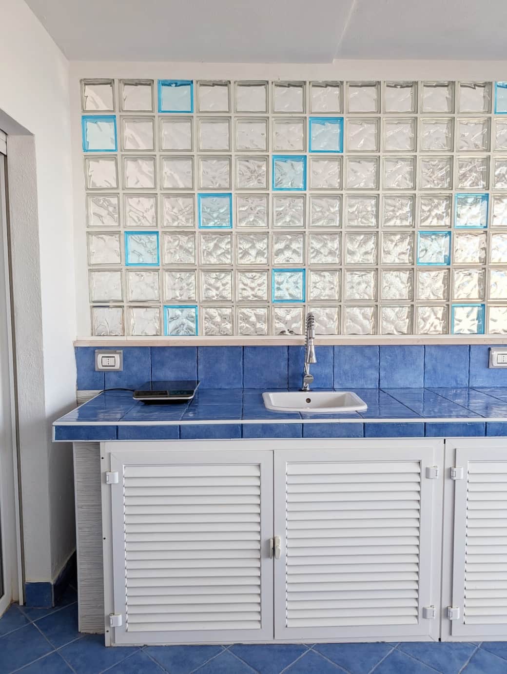 Outdoor kitchen area with blue tiles and sink