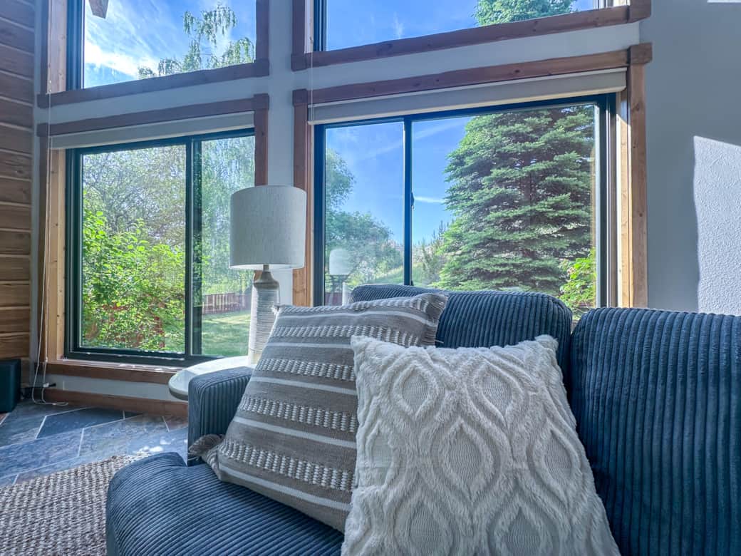 Large beautiful windows with beautiful views - out in the yard are various trees including pine, app